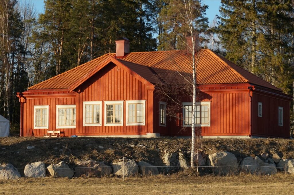 Stort rött hus som är målad med linoljefärg från Selder och Co